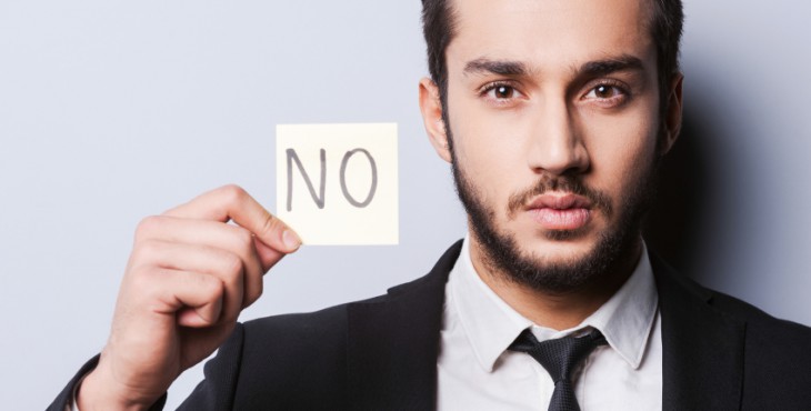 I said No. Handsome young man in formalwear holding adhesive note while standing against grey background