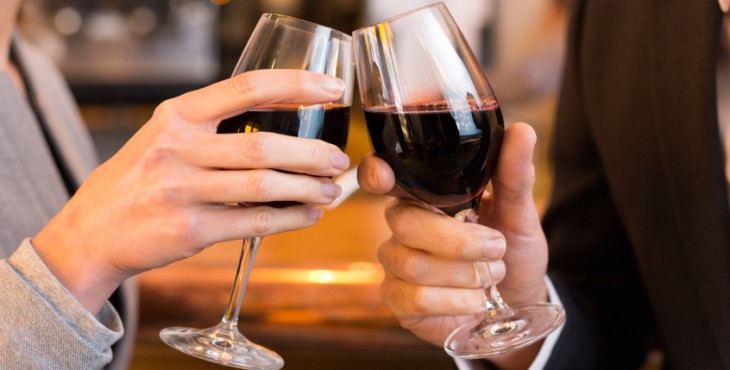 Close Up of Couple Toasting with red wine glass in restaurant