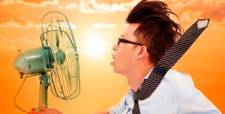the heat wave is coming,business man holding a electric fan