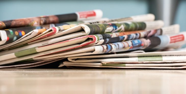 Stack of newspapers on white wood table